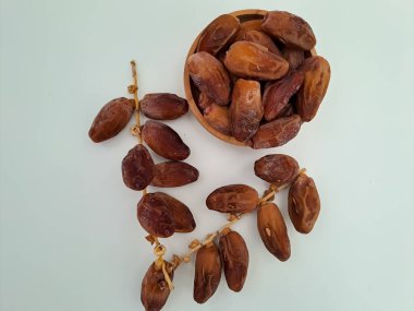 Tunisian dates fruit isolated on white background. The Deglet Nour, sweet dried palm fruit popular in ramadhan for breakfasting or takjil. Selective focus