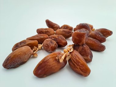Tunisian dates fruit isolated on white background. The Deglet Nour, sweet dried palm fruit popular in ramadhan for breakfasting or takjil. Selective focus