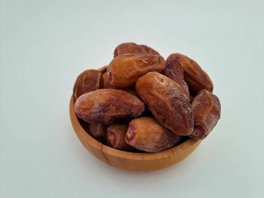 Tunisian dates fruit isolated on white background. The Deglet Nour, sweet dried palm fruit popular in ramadhan for breakfasting or takjil. Selective focus