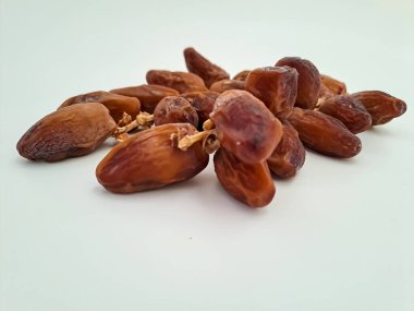 Tunisian dates fruit isolated on white background. The Deglet Nour, sweet dried palm fruit popular in ramadhan for breakfasting or takjil. Selective focus
