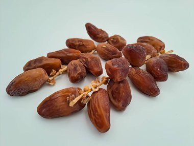 Tunisian dates fruit isolated on white background. The Deglet Nour, sweet dried palm fruit popular in ramadhan for breakfasting or takjil. Selective focus