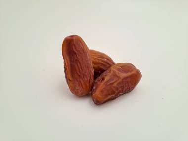 Tunisian dates fruit isolated on white background. The Deglet Nour, sweet dried palm fruit popular in ramadhan for breakfasting or takjil. Selective focus