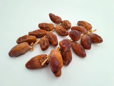 Tunisian dates fruit isolated on white background. The Deglet Nour, sweet dried palm fruit popular in ramadhan for breakfasting or takjil. Selective focus