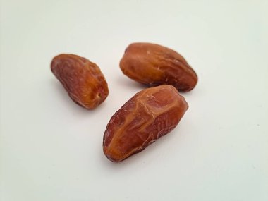 Tunisian dates fruit isolated on white background. The Deglet Nour, sweet dried palm fruit popular in ramadhan for breakfasting or takjil. Selective focus