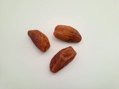 Tunisian dates fruit isolated on white background. The Deglet Nour, sweet dried palm fruit popular in ramadhan for breakfasting or takjil. Selective focus