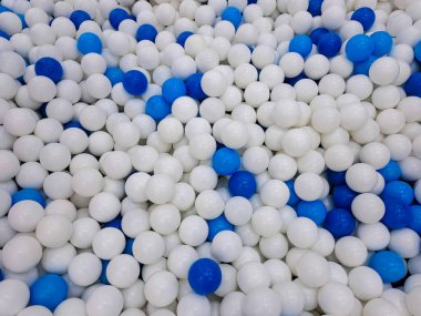 Çocuk parkı için plastik toplarla dolu kuru havuz. Eğlence için mavi ve beyaz toplar solgun