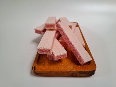 Beyaz arka planda izole edilmiş ahşap tepside servis edilen çilek aromalı gofretler.