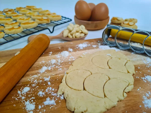 Home baking concept, making peanut cookies with the ingredients, flour, egg, dough, rolling pin and the cutter. Selective focus