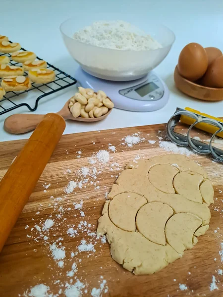 Home baking concept, making peanut cookies with the ingredients, flour, egg, dough, rolling pin and the cutter. Selective focus