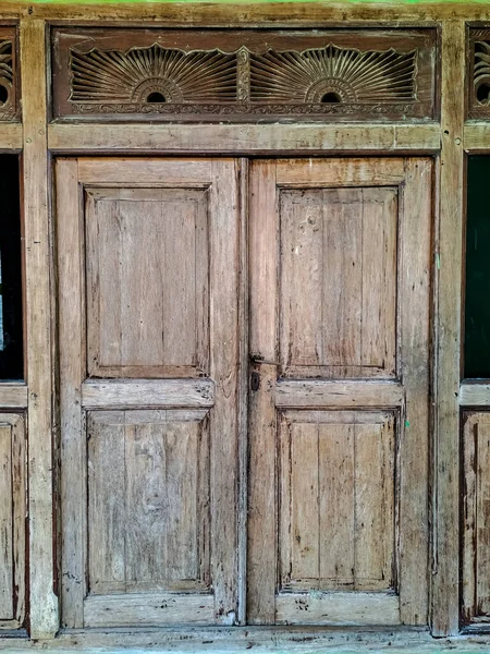 インドネシアの伝統的なジャワの家で木製のドアを彫るの古いとコーティングされていない — ストック写真