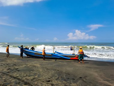 Balıkçıların avını seçmek ve satın almak için teknenin etrafındaki insanları görmek. Yogyakarta, Endonezya - 23 Nisan 2023