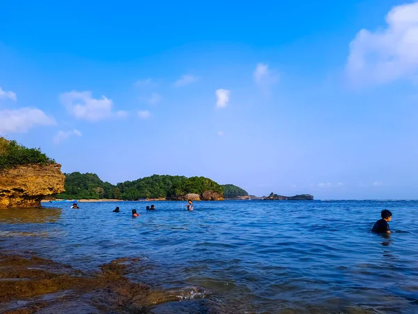 Laut Dan Langit Biru Dengan Beberapa Wisatawan Berenang Dan Batu — Stok Foto