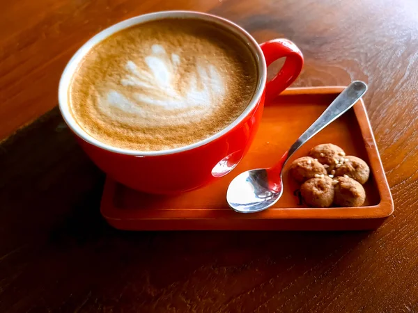 Kubek Gorącego Cappuccino Sztuką Latte Rano Podawany Czerwonym Kubku Ciasteczkiem — Zdjęcie stockowe