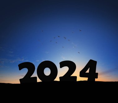 Yeni yıl 2024, gün batımında. Siluet 2024 gün doğumunda güneş ışınlarıyla bir dağın tepesinde duruyor. Yaratıcı bir fikir. Yıl 2024, kavram