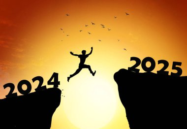 2025 no 'lu uçurumdan atlayan bir adam, gün batımında taşlarla birlikte inanılmaz bir şekilde uçurumdan atlıyor. Yeni yıl konsepti. 2024 sonsuzluğa düşer. Hoş geldin 2025. İnsanlar 2025 yılına giriyor, yaratıcı fikir..