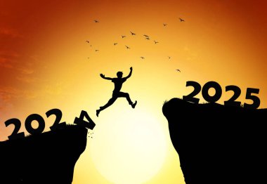 2025 no 'lu uçurumdan atlayan bir adam, gün batımında taşlarla birlikte inanılmaz bir şekilde uçurumdan atlıyor. Yeni yıl konsepti. 2024 sonsuzluğa düşer. Hoş geldin 2025. İnsanlar 2025 yılına giriyor, yaratıcı fikir..
