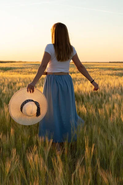 Kız tarlada buğday ekiyor.
