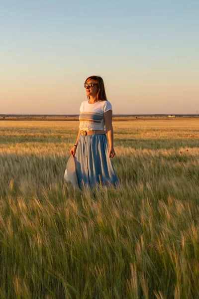 Kız tarlada buğday ekiyor.