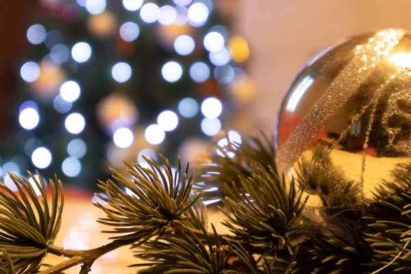 Arka planda gümüş top ve ağaç olan Noel süslemeleri.