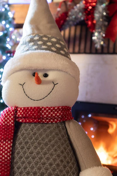 Noel bebeği, şömine, ışık ve dekore edilmiş ağaç süslemeleri.