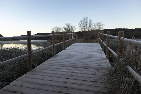 Göl manzaralı, kışın sisli, bir köprüden görünen bir yer..