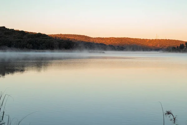 Güneşin doğuşundan önce kışın sisli göl manzarası
