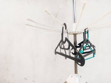 Birkaç siyah askılık ve elbiselere takılmış yeşil bir askılık.