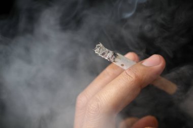 Sigara içen bir adamın iki parmağında sigara. Görüntüyü kapat. 