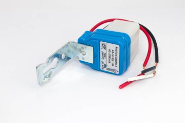 Beyaz arkaplanda kablo rehberi olan fotoğraf sensörü kullanarak otomatik sokak lambası denetimi.