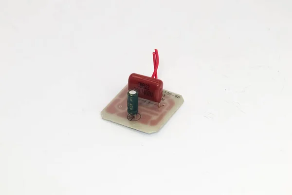 Beyaz Zemin Üzerinde Kırmızı Kablolar Olan Iki Kapasitörlü Bir Pcb — Stok fotoğraf