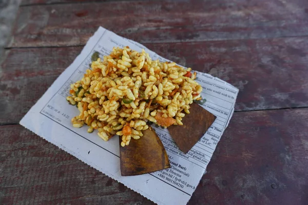 jhalmuri sebze ve keskin tamarind sosundan yapılmış tuzlu bir üründür. Popüler yol kenarı yemekleri. Karmaşık arka planda kağıt tabakta servis edilmiş. Seçici odak