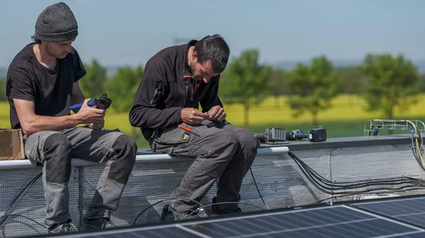 team of workers preparing electrical connection cables for solar panels