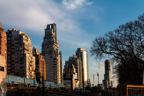 Tren Buenos Aires 'te gün batımında binaların yanından geçer.