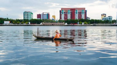 Makassar, 16 Mayıs 2022: Yerel balıkçılar Losari sahilinin tekneden manzarasının tadını çıkarıyorlar