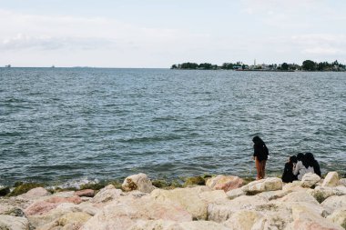 Best friends enjoying the atmosphere sitting by the beach with copy space