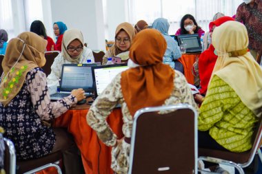 Bekasi, October 11, 2022: a female accountant wearing a hijab has a serious expression when making an annual report