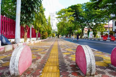 Makassar, October 16, 2022: a beautiful pedestrian path with vehicle blocks and a pattern for the path of the blind in the area near the Makassar city hall building