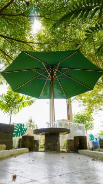 Cement garden chairs and umbrellas to protect from the hot sun. Portrait photo