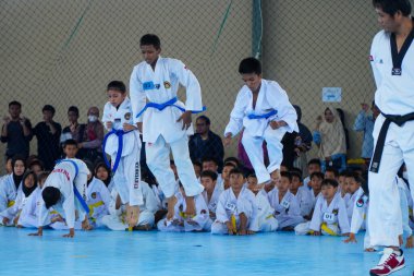 25 Aralık 2022 'de Makassar' da tekvando için beden eğitimi alan mavi kemerli bir çocuk.