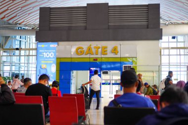 Bustling crowd at Gate 4, awaiting flight departures at Sultan Hasanuddin Airport in Makassar on January 9, 2023 clipart