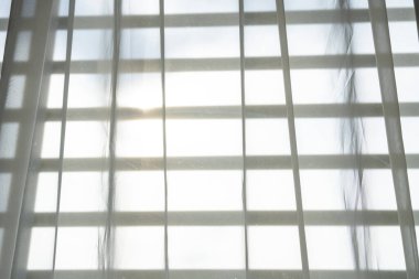 Güneş ışığını engelleyen beyaz kumaş perdeler