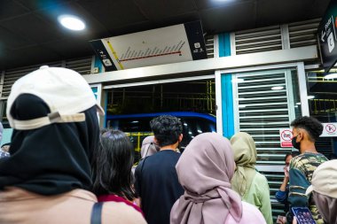 1 Haziran 2023 'te Kuzey Jakarta' daki Ancol otobüs durağında uzun kuyruklarda bekleyen kalabalık otobüs yolcuları.