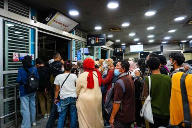 Otobüs yolcuları 1 Haziran 2023 'te Ancol otobüs durağı, Kuzey Jakarta' da otobüse binerken itişip kakışırlar.