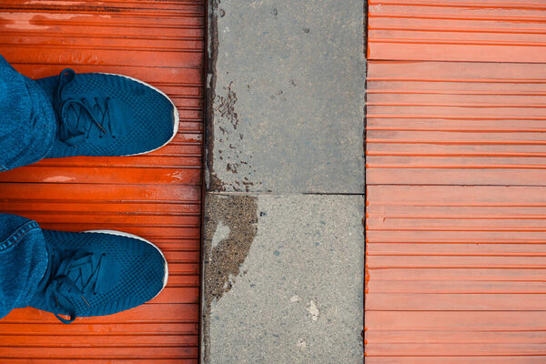 Ноги в синих туфлях стоят на деревянном виниловом полу