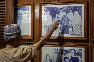 Bengkulu, Endonezya - 20 Mart 2024: Bir rehber, Başkan Soekarno 'nun üçüncü karısı Fatmawati' nin Bengkulu 'daki evinde aile fotoğrafının arkasındaki hikayeyi anlatır.