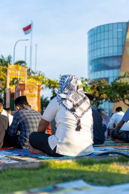 Türban takan Müslüman bir adam bayram konferansını dinliyor. Açık alanda Kurban vaazını dinlerken...