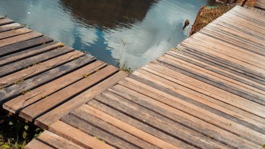 Göl kenarındaki ahşap patikada nostaljik ve sinematik bir his var.