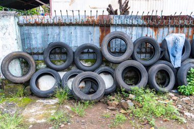 Rusty Fence 'e Karşı Eski Lastikler Yığını