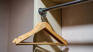 Modern bir gardırop bölümünde görülen ahşap askılar. Bir otel odasının gardırobundaki askıda.