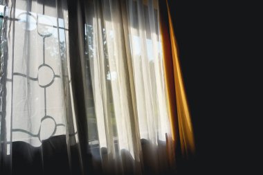 Parlak güneş ışığı, şeffaf perdelerden süzülerek odada yumuşak ve davetkar bir ortam yaratıyor. Doğal ışık ve kumaş dokularının birleşimi huzurlu ve rahat bir atmosfer yaratır.